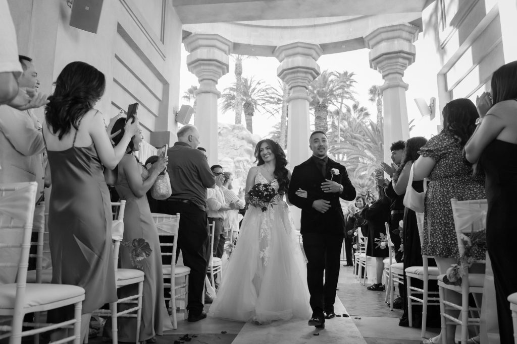 Bride and groom walking down aisle at Mandalay Bay Valley of the Falls ceremony black and white