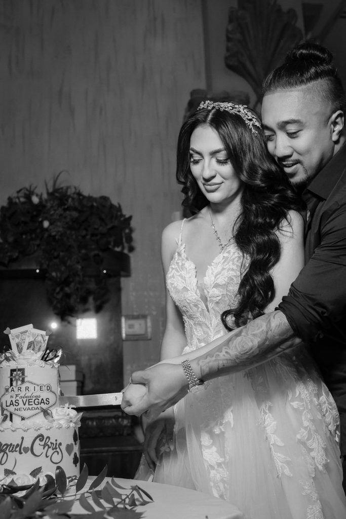 Bride and groom cutting wedding cake in black and white