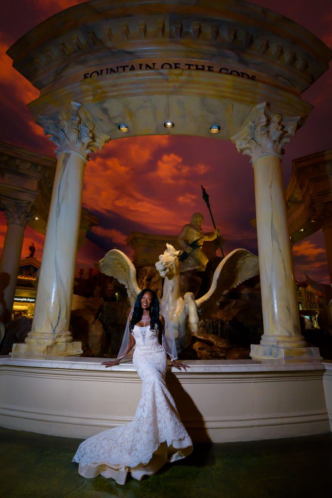 Las Vegas Strip elopement bride portrait at Caesars Palace Forum Shops with dramatic ceiling sky and statues at night, photographed by Zoltan Redl-Nagy