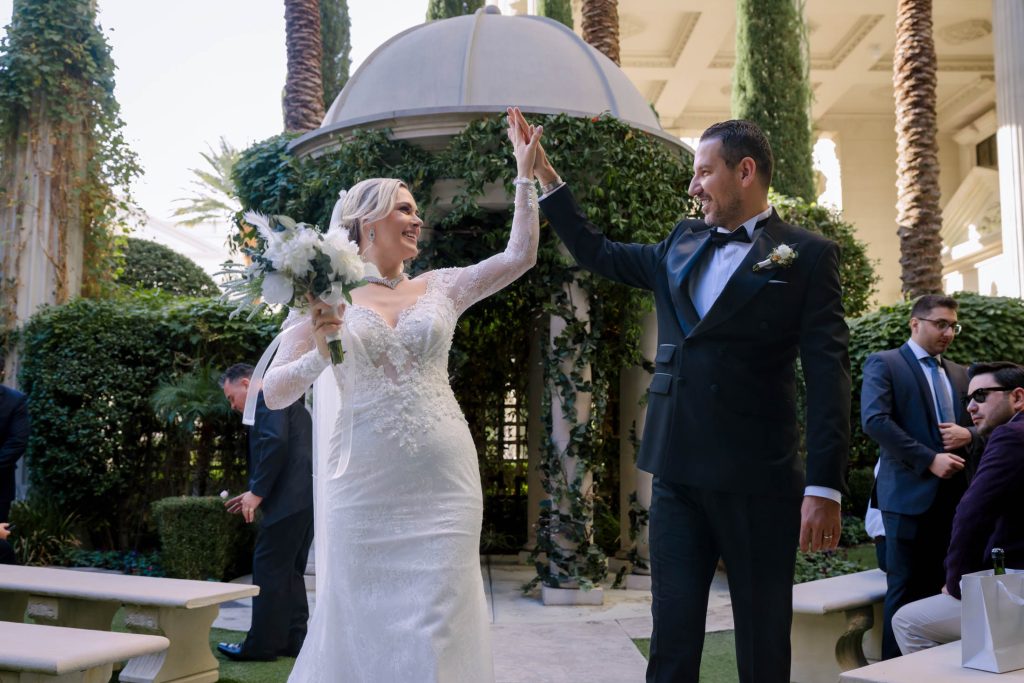 bride and groom celebrating exit at Caesars Palace Venus Garden Las Vegas wedding photographed by Zoltan Redl Nagy
