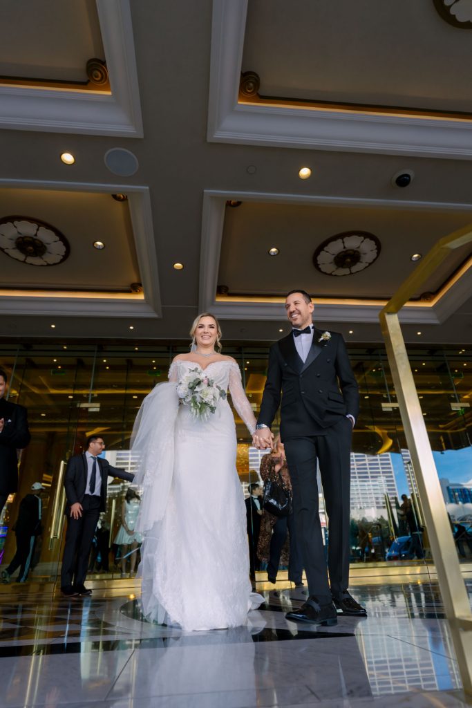 bride and groom walking out of Caesars Palace hotel entrance Las Vegas wedding photographed by Zoltan Redl Nagy