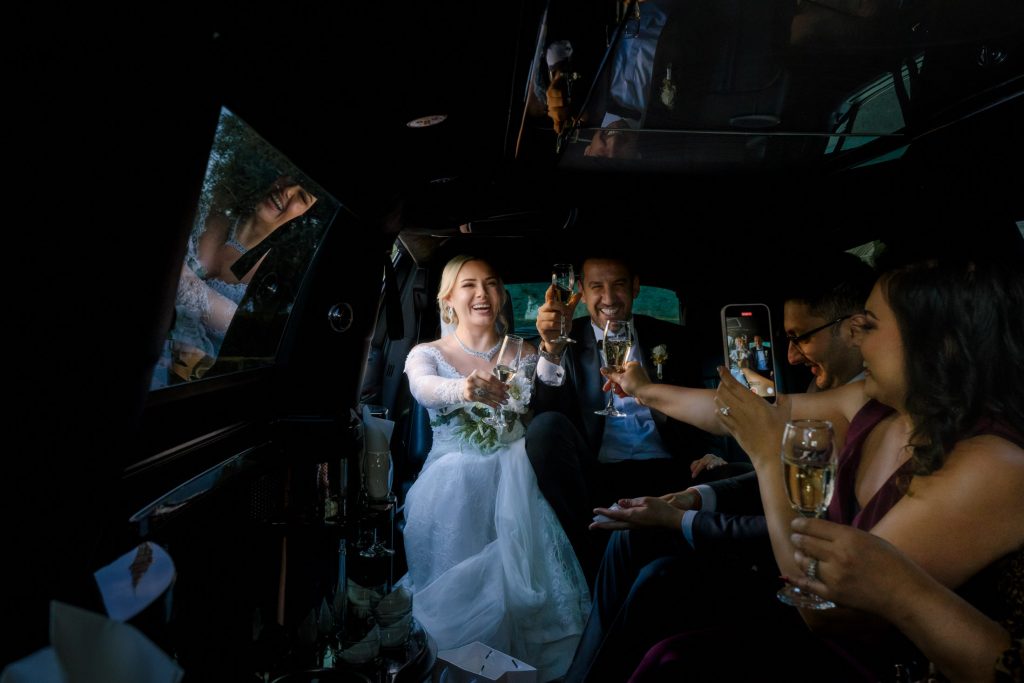 bride and groom champagne toast with friends in limousine Las Vegas wedding celebration photographed by Zoltan Redl Nagy