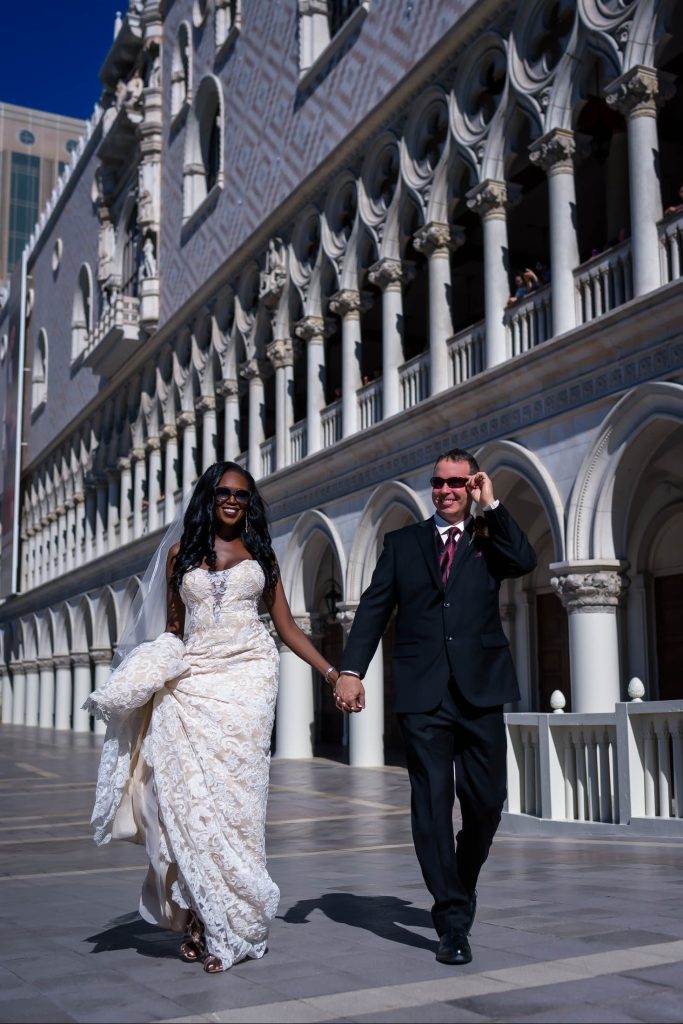 Las Vegas Strip elopement couple walking at The Venetian Grand Canal during daytime with elegant architecture, photographed by Zoltan Redl-Nagy