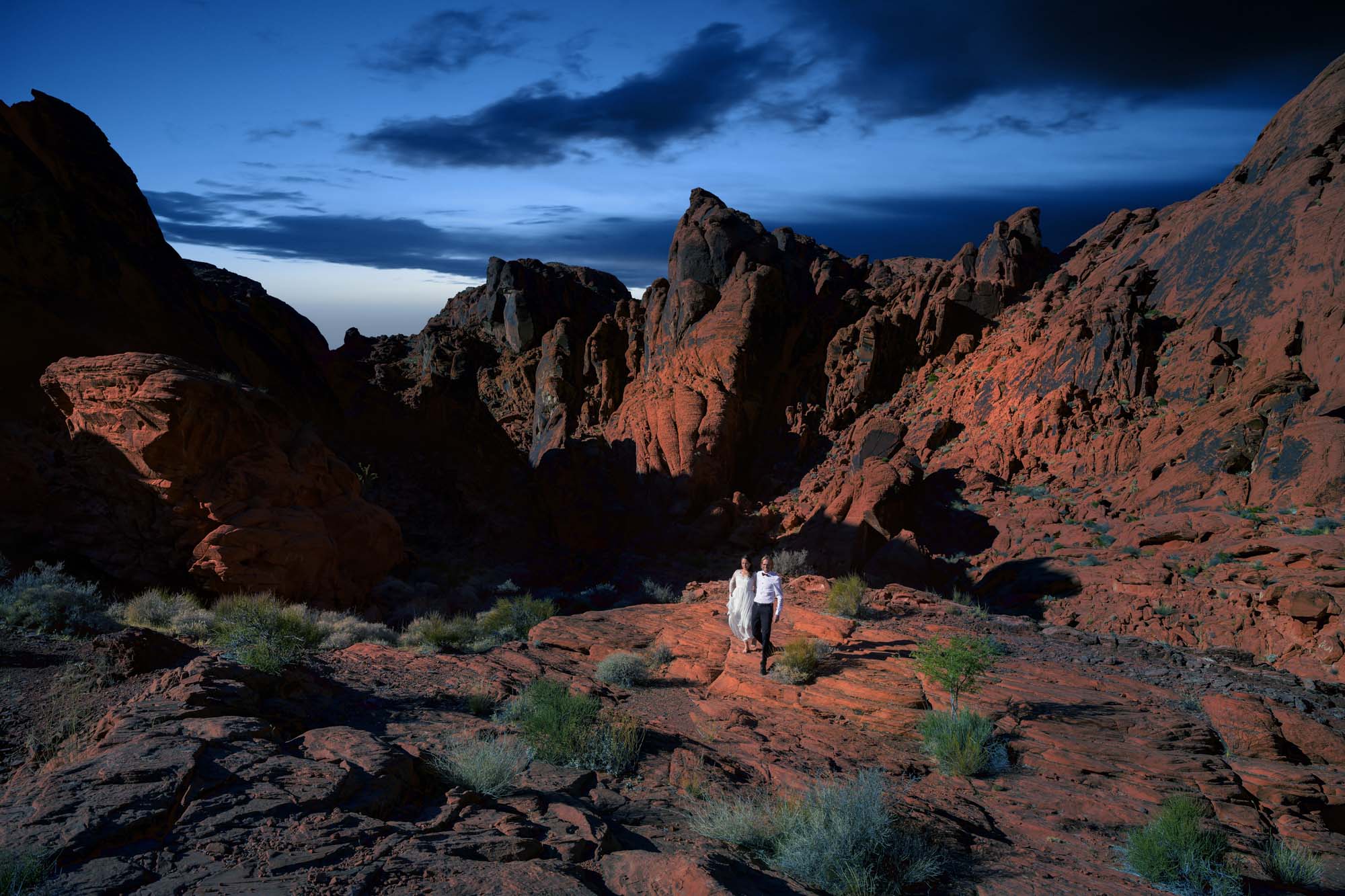 Valley of Fire blue hour elopement couple walking through red rock formations Nevada photographed by Zoltan Redl Nagy