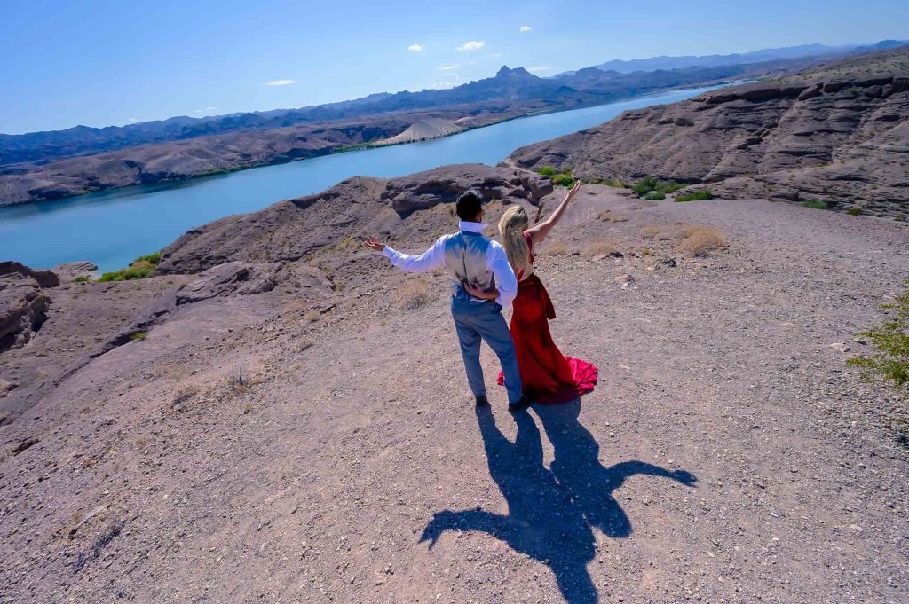 Couple walking together above Colorado River desert landscape near Las Vegas Nevada elopement