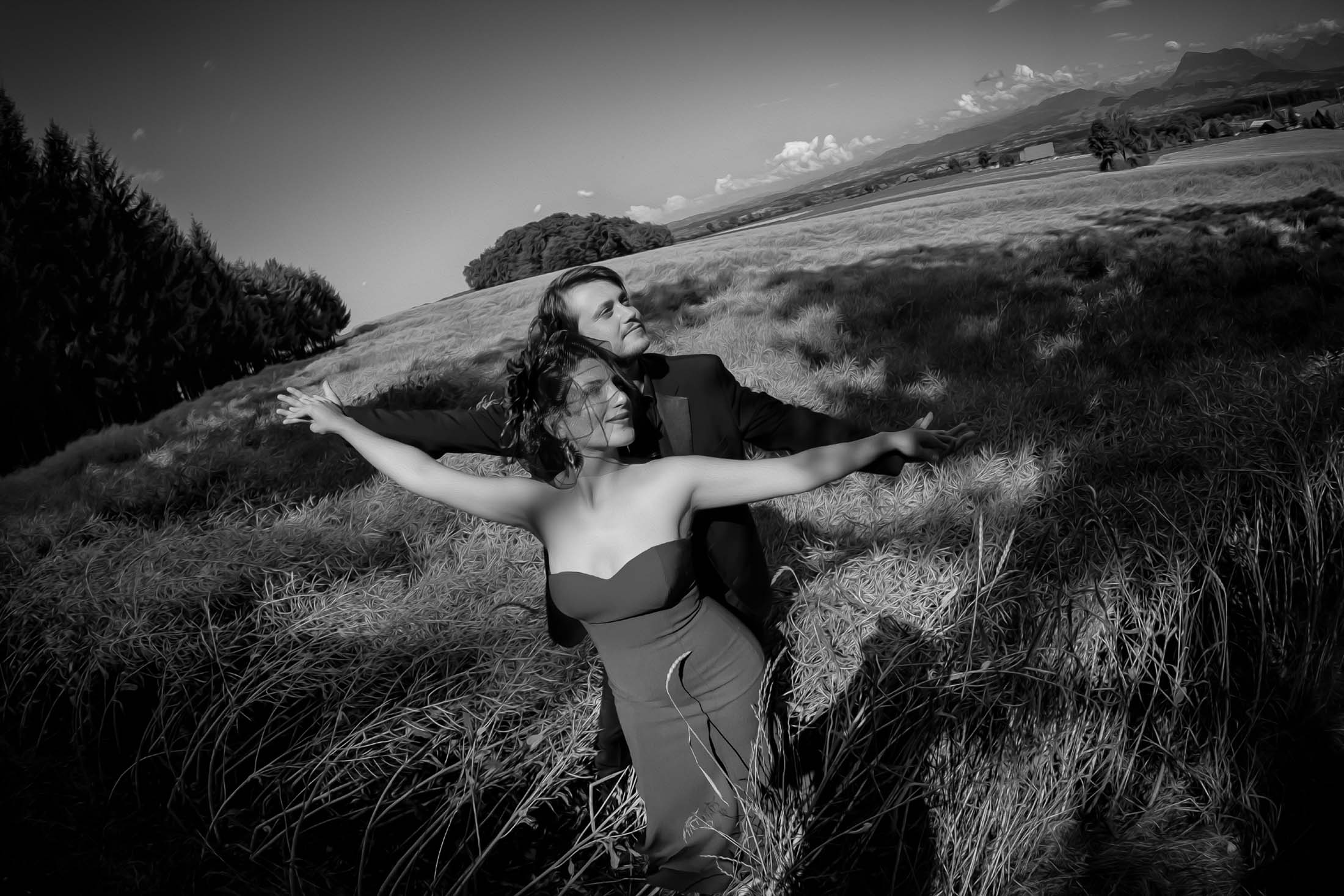 Engagement couple in open field with arms wide black and white romantic motion photographed by Zoltan Redl Nagy