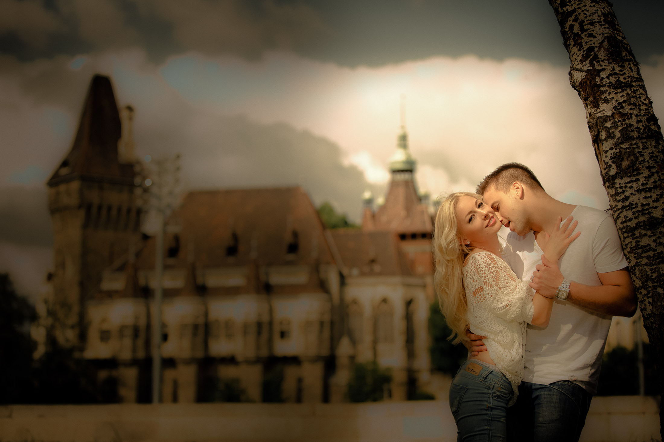 Engagement couple embracing at Vajdahunyad Castle Budapest during sunset romantic moment photographed by Zoltan Redl Nagy