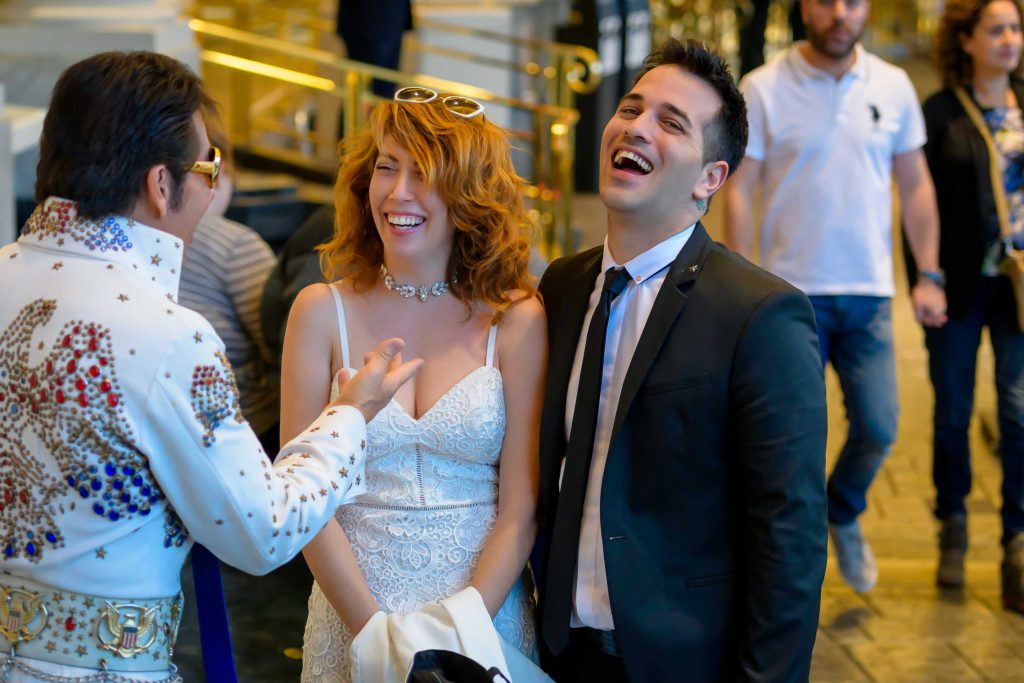 Las Vegas Elvis elopement couple meeting Elvis officiant at Caesars Palace with candid laughter, photographed by Zoltan Redl-Nagy