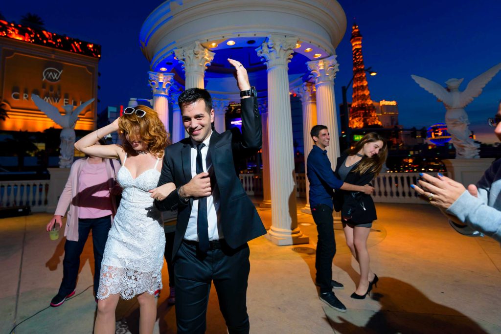 Las Vegas Elvis elopement celebration with couple dancing at Caesars Palace gazebo at night and Eiffel Tower in background, photographed by Zoltan Redl-Nagy