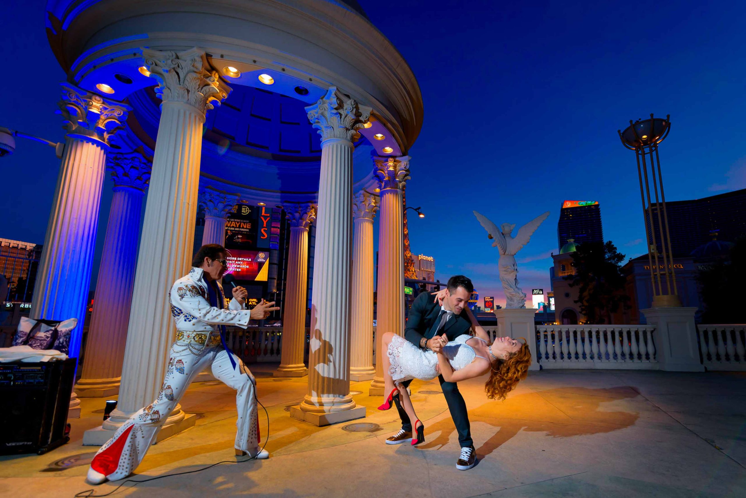 Las Vegas Elvis elopement dip kiss at Caesars Palace gazebo at night with couple and Elvis officiant performing, iconic wedding moment, photographed by Zoltan Redl-Nagy