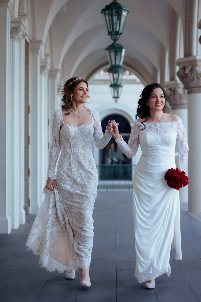 Same-sex elopement brides walking together in Venetian Las Vegas photographed by Zoltan Redl Nagy