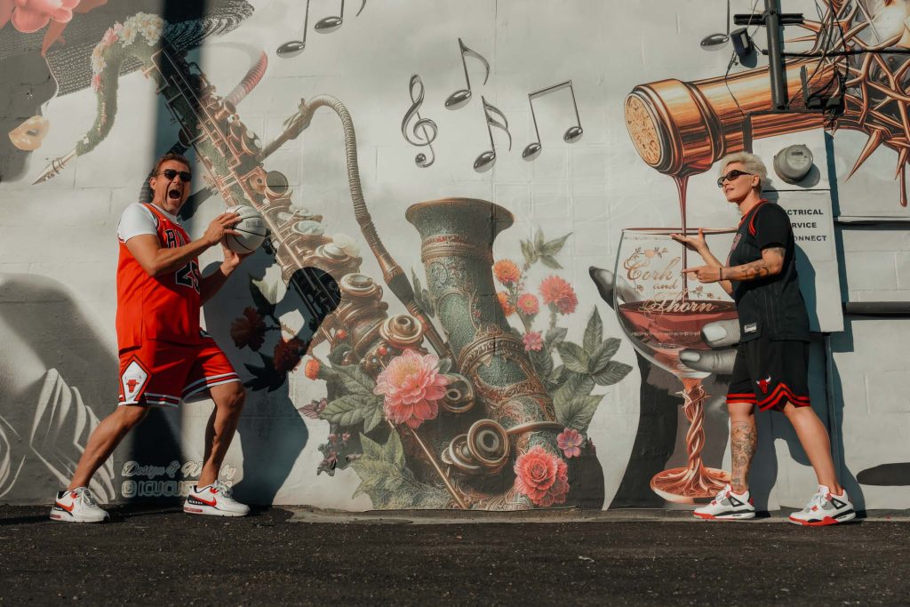 Renewal elopement couple in Las Vegas Arts District with basketball posing in front of music-themed mural, photographed by Zoltan Redl Nagy.
