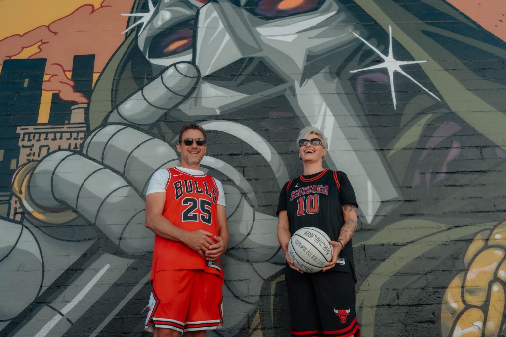 Renewal elopement couple in Las Vegas Arts District standing with basketball in front of large graffiti mural, photographed by Zoltan Redl Nagy.