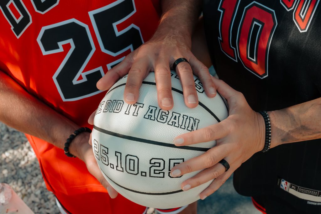 Close-up of renewal elopement couple’s hands with rings holding a basketball in Las Vegas Arts District, photographed by Zoltan Redl Nagy.