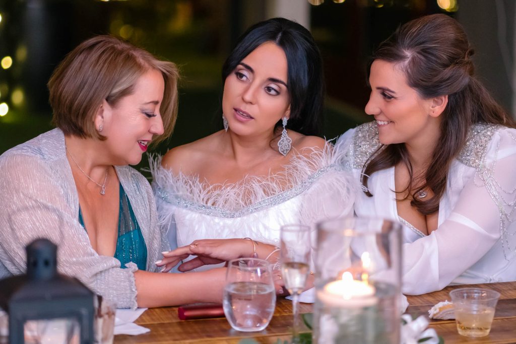 Same sex wedding brides sharing emotional moment with guest at reception in Las Vegas, photographed by Zoltan Redl Nagy.