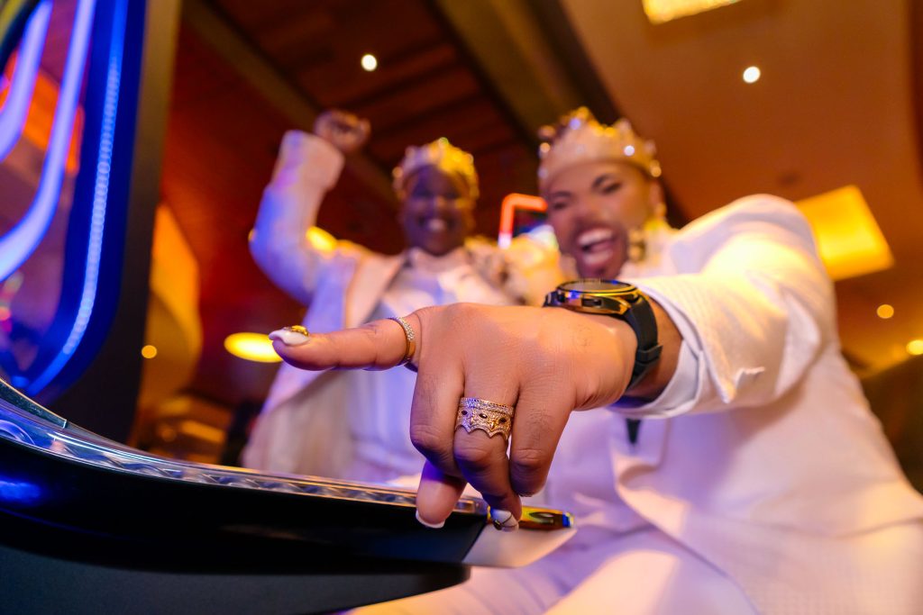 Same sex wedding couple celebrating at slot machine in Las Vegas with rings detail, photographed by Zoltan Redl Nagy.