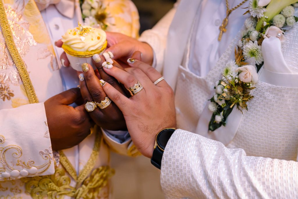 Same sex wedding couple hands with rings sharing cupcake detail in Las Vegas, photographed by Zoltan Redl Nagy.