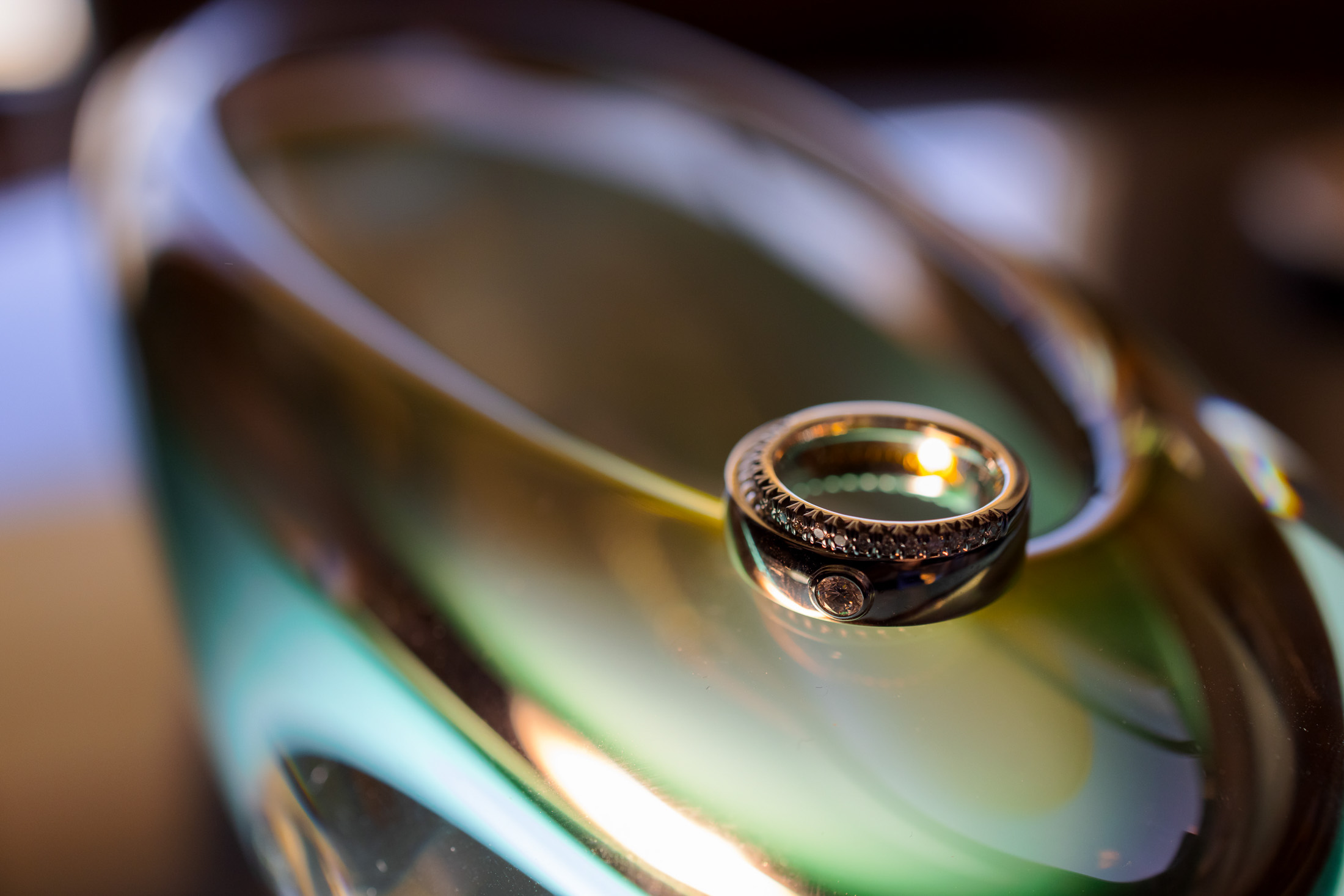 Creative wedding ring macro on reflective glass surface with soft light and bokeh Las Vegas