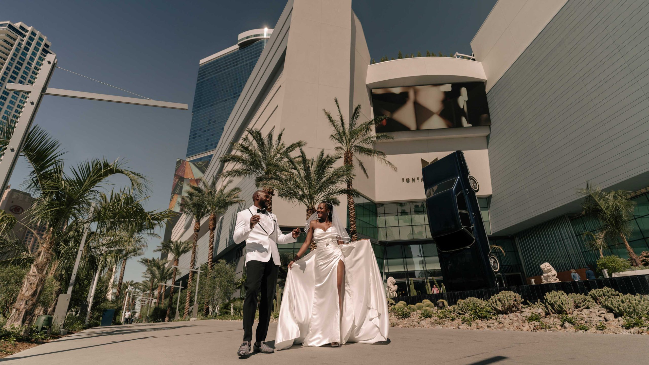 Stylish Fontainebleau Las Vegas hotel wedding portrait with bride and groom walking together on the Las Vegas Strip