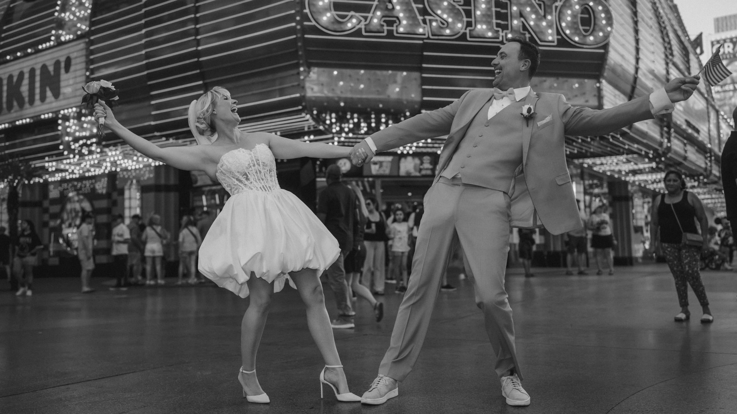 Las Vegas Downtown elopement couple celebrating in front of Binion's Casino on Fremont Street at night in a timeless black and white photograph.