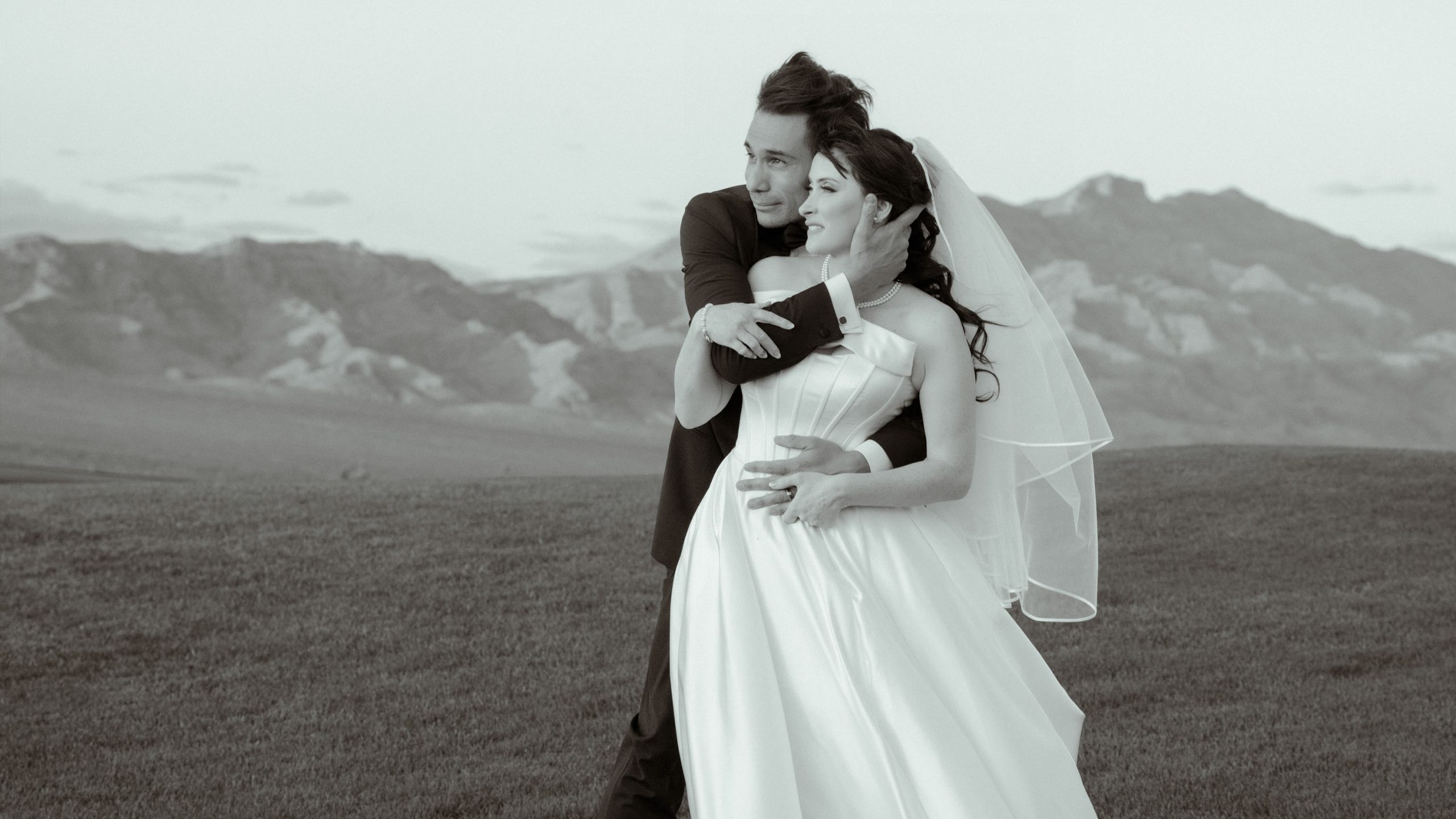 Black and white wedding portrait of a bride and groom embracing in the Nevada desert at Paiute Golf Resort near Las Vegas.