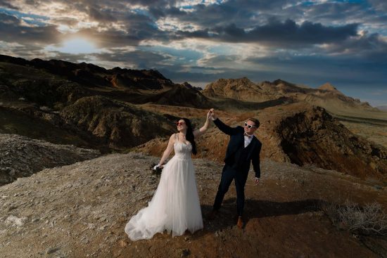 Valley of Fire elopement couple celebrating on mountain ridge at sunset Nevada photographed by Zoltan Redl Nagy
