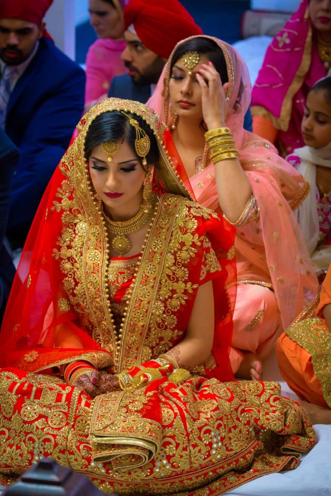 indian wedding bride during traditional ceremony wearing red bridal attire