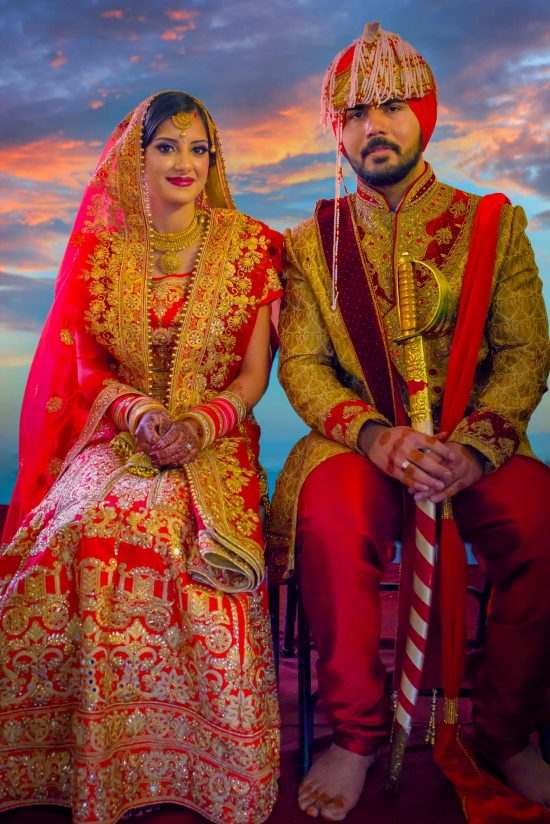 indian wedding bride and groom traditional portrait in red and gold attire