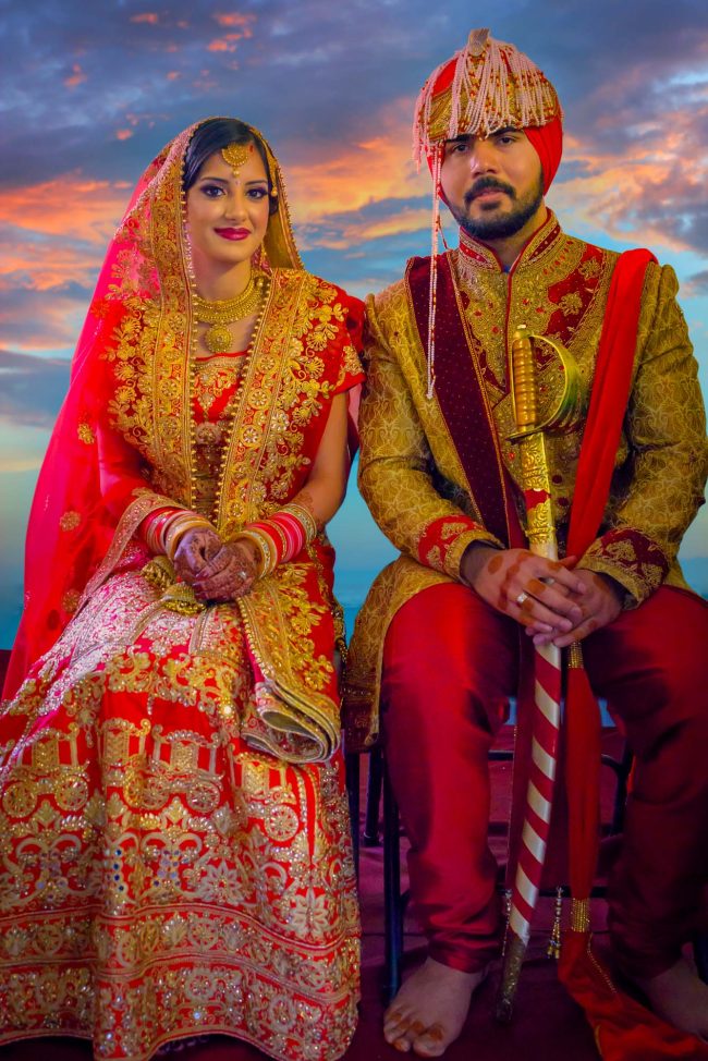 indian wedding bride and groom traditional portrait in red and gold attire