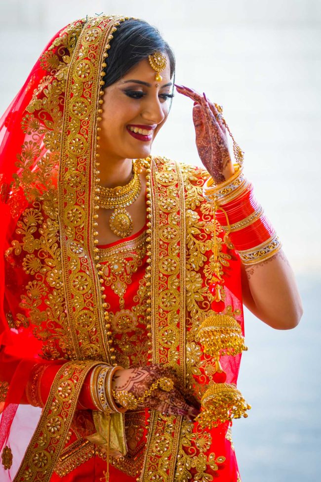 indian wedding bride portrait in traditional red bridal attire with gold jewelry