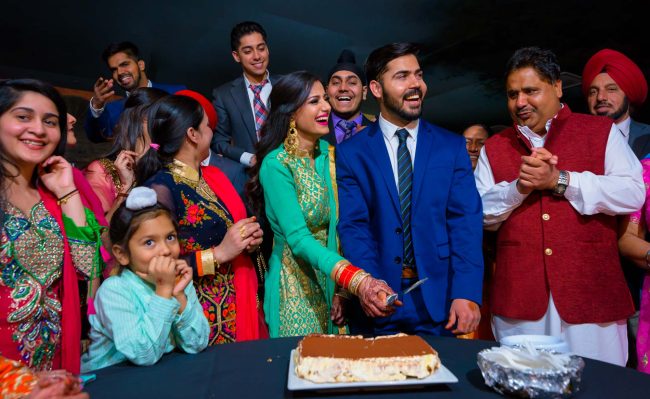 indian wedding reception cake cutting celebration with family photo by zoltan redl-nagy