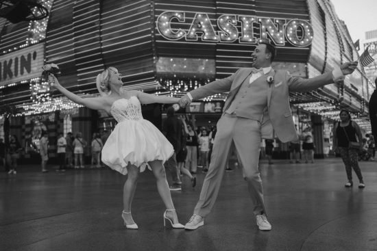 Las Vegas Downtown elopement couple celebrating in front of Binion's Casino on Fremont Street in a timeless black and white wedding portrait.