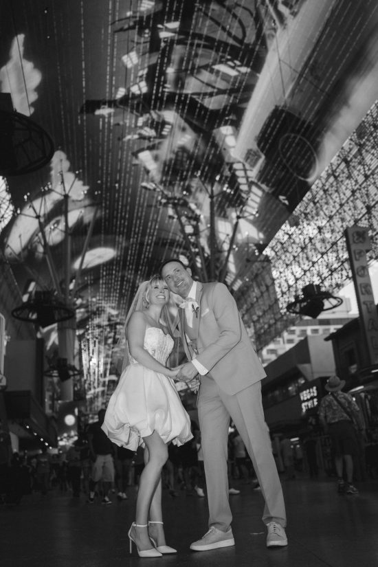 Romantic Las Vegas Downtown elopement couple beneath the Fremont Street Experience canopy in an elegant black and white wedding portrait.
