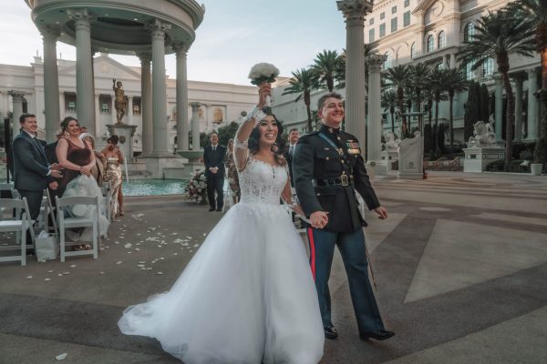 Bride proudly raising her bouquet after a Caesars Palace wedding ceremony in Las Vegas.