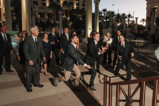 Wedding guests reaching for the bridal bouquet during a Caesars Palace wedding reception in Las Vegas.
