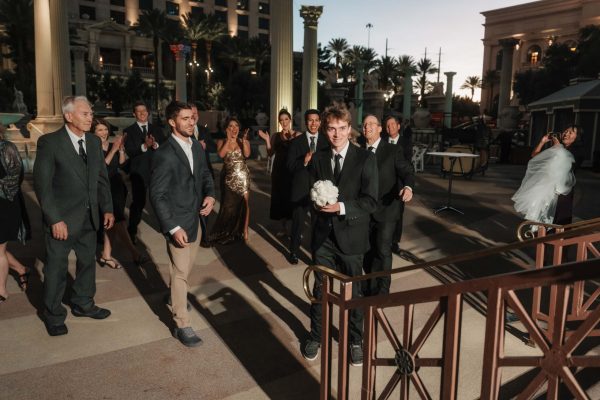 Wedding guest celebrates after catching the bridal bouquet during a Caesars Palace wedding ceremony in Las Vegas.