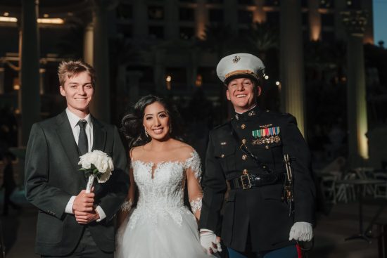 Bride and U.S. Marine groom posing with the guest who caught the wedding bouquet during their Caesars Palace wedding in Las Vegas.