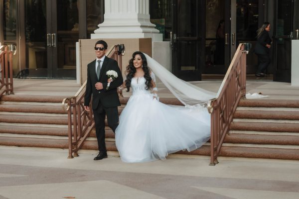 Bride walking with her brother before an outdoor Caesars Palace wedding ceremony in Las Vegas.