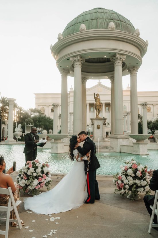 Luxury Caesars Palace wedding ceremony kiss at the Fountain of the Gods with a U.S. Marine groom and bride in Las Vegas.