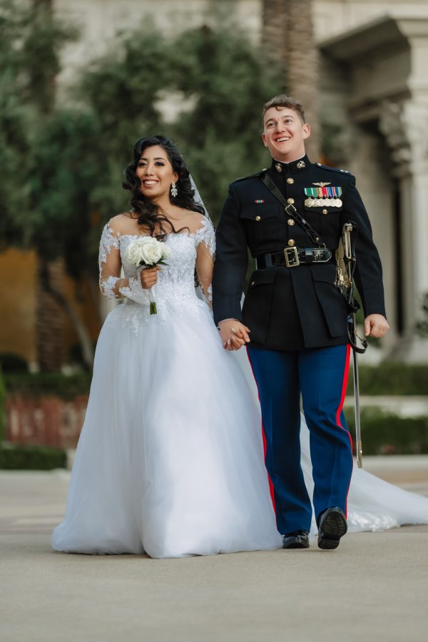 Luxury Caesars Palace wedding couple walking hand in hand with the groom in U.S. Marine dress uniform in Las Vegas.