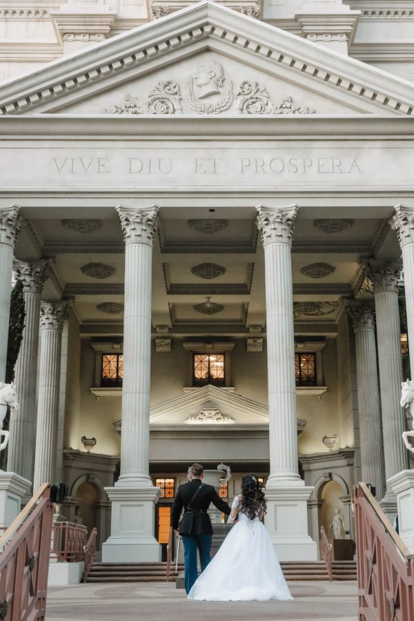 Luxury Caesars Palace wedding couple walking toward the iconic Roman architecture after their ceremony in Las Vegas.