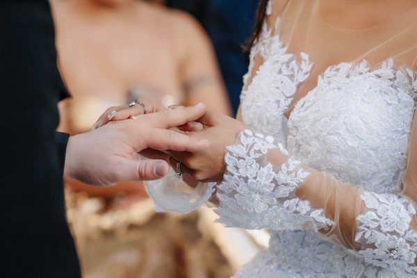 Bride and groom exchanging wedding rings during an outdoor Caesars Palace wedding ceremony in Las Vegas.