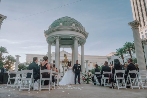 Outdoor wedding ceremony at Caesars Palace in Las Vegas with guests gathered around the bride and groom.