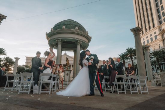 Bride and groom sharing their first kiss after a Caesars Palace wedding ceremony in Las Vegas.