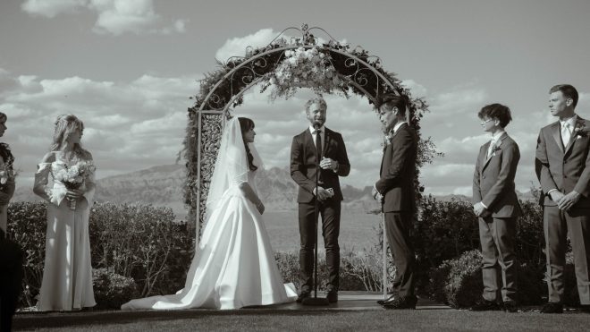 Bride and groom exchanging vows during an outdoor wedding ceremony at Las Vegas Paiute Golf Resort with mountain views in the background