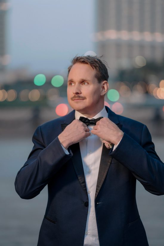 Groom adjusting his bow tie during a luxury Las Vegas elopement at Paris Las Vega
