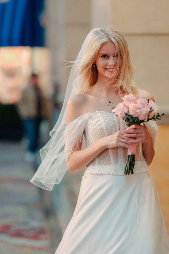 Bride smiling with bouquet inside Paris Las Vegas during a romantic Las Vegas elopement.