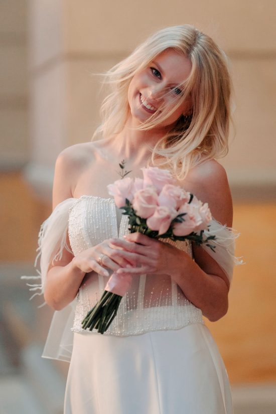 Smiling bride holding a bouquet during her Paris Las Vegas hotel elopement.