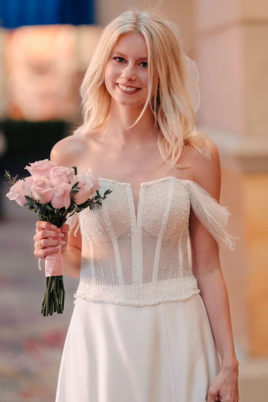 Smiling bride holding a pink bouquet during her Paris Las Vegas hotel elopement.