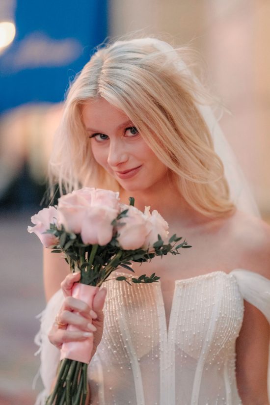 Bride with a playful smile holding her bouquet during a romantic Paris Las Vegas elopement.